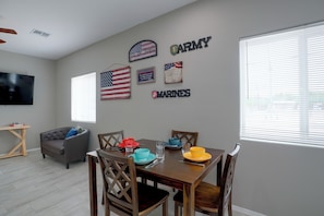 A dining area with a wooden table set for four, surrounded by chairs. - Townhome 1 Mi to Midtown & Botanical Gardens! (Tucson)