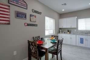 A dining area with a table set for four, surrounded by wooden chairs. - Townhome 1 Mi to Midtown & Botanical Gardens! (Tucson)