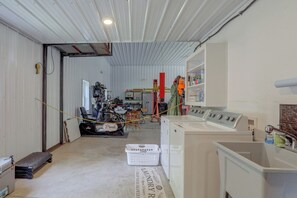 A laundry facility with a washing machine, a dryer, and a utility cart.