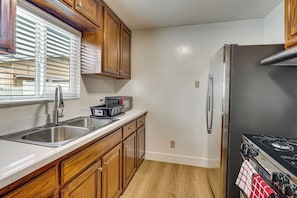 A kitchen with wooden cabinets, a stainless steel sink, a microwave, a refrigerator, and a stove. - Fullerton Suite w/ Private Yard, Extended Stays (Fullerton)