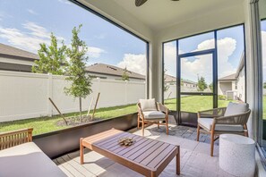 A balcony with a wooden table, two chairs, and a view of a residential area. - Private Community w/ Pool, Near Gulf Beaches (Palmetto)