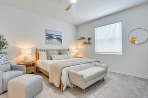 A bedroom with a bed, bedside tables, a chair, a bench, a painting, shelves, and a window with blinds. - Private Community w/ Pool, Near Gulf Beaches (Palmetto)