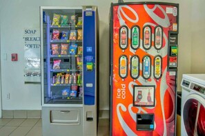 Un distributeur automatique proposant une variété de collations, ainsi qu’un autre distributeur automatique de glaces situé à proximité.