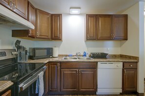 A kitchen with wooden cabinets, a microwave, a stove, a dishwasher, and a granite countertop. - 12 Mi to JBLM: Olympia-Area Escape (Lacey)