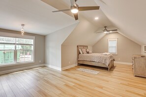 A bedroom with a sloped ceiling, a bed, a ceiling fan, and a window with blinds. - Pool & Hot Tub at Gated Waverly Home (Waverly)