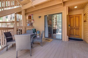 A covered outdoor area with wicker furniture, a fire extinguisher, and a sliding glass door leading to a kitchen. - Incline Village Condo Near Lake Tahoe Adventures (Incline Village)
