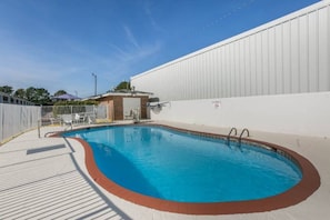 A swimming pool with a small adjacent structure, a fenced area, and a clear sky. - 2 Queen Beds | Ada/Roll-In Shower, Nsmk (Dothan)