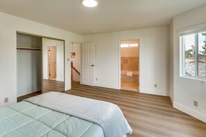 A bedroom with a bed, a closet, a hallway, and a bathroom with a bathtub. - 4BR Fullerton Home, 9 Mi to Cal State (Fullerton)