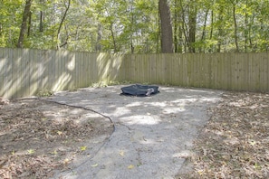 A fenced outdoor area with a gravel surface and a black object on it. - 10 Mi to Dtwn Little Rock! Patio & Fire Pit (Mabelvale)