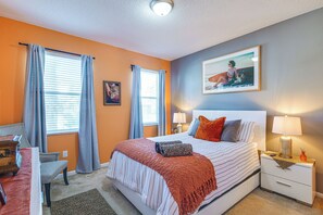 A bedroom with a bed, a nightstand, a lamp, a chair, and a painting on the wall. - 8 Mi to Disney! Whimsical Home w/ Pool & Game Room (Kissimmee)