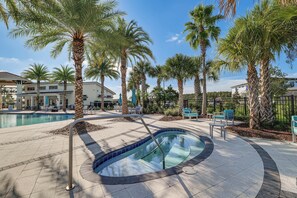 A pool area with palm trees, lounge chairs, and a hot tub. - 8 Mi to Disney! Whimsical Home w/ Pool & Game Room (Kissimmee)