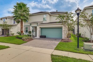 A residential building with a garage, a driveway, and a well-maintained lawn. - 8 Mi to Disney! Whimsical Home w/ Pool & Game Room (Kissimmee)