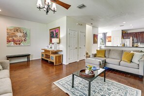 A living room with hardwood flooring, a sofa, a coffee table, and a painting on the wall. - Pool Access! Steps from Upper Tampa Bay Trail (Tampa)