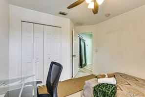 A room with a bed, a chair, a desk, and a door. - Pool Access! Steps from Upper Tampa Bay Trail (Tampa)