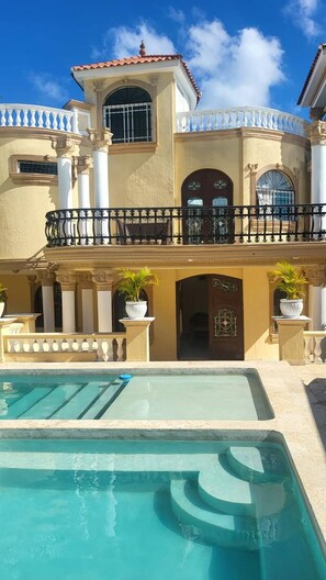 A large, two-story building with a pool in the foreground. - Luxurious Colonial Mansion in Puerto Plata with Private Pool (Puerto Plata)