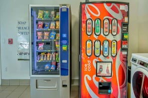 A vending machine with a variety of snacks and a nearby ice cream vending machine. - 1 Queen Bed | Smoking, Micfridge (PHOENIX)