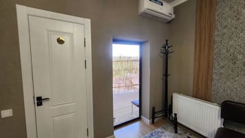 A room with a white door, a radiator, a black coat stand, and a patterned rug.