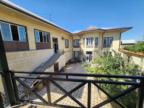 A residential building with a covered outdoor area, a staircase, and a balcony with a metal railing. - Ideal & Comfort room for 3 guests in Hotel Incity (Тошкент)