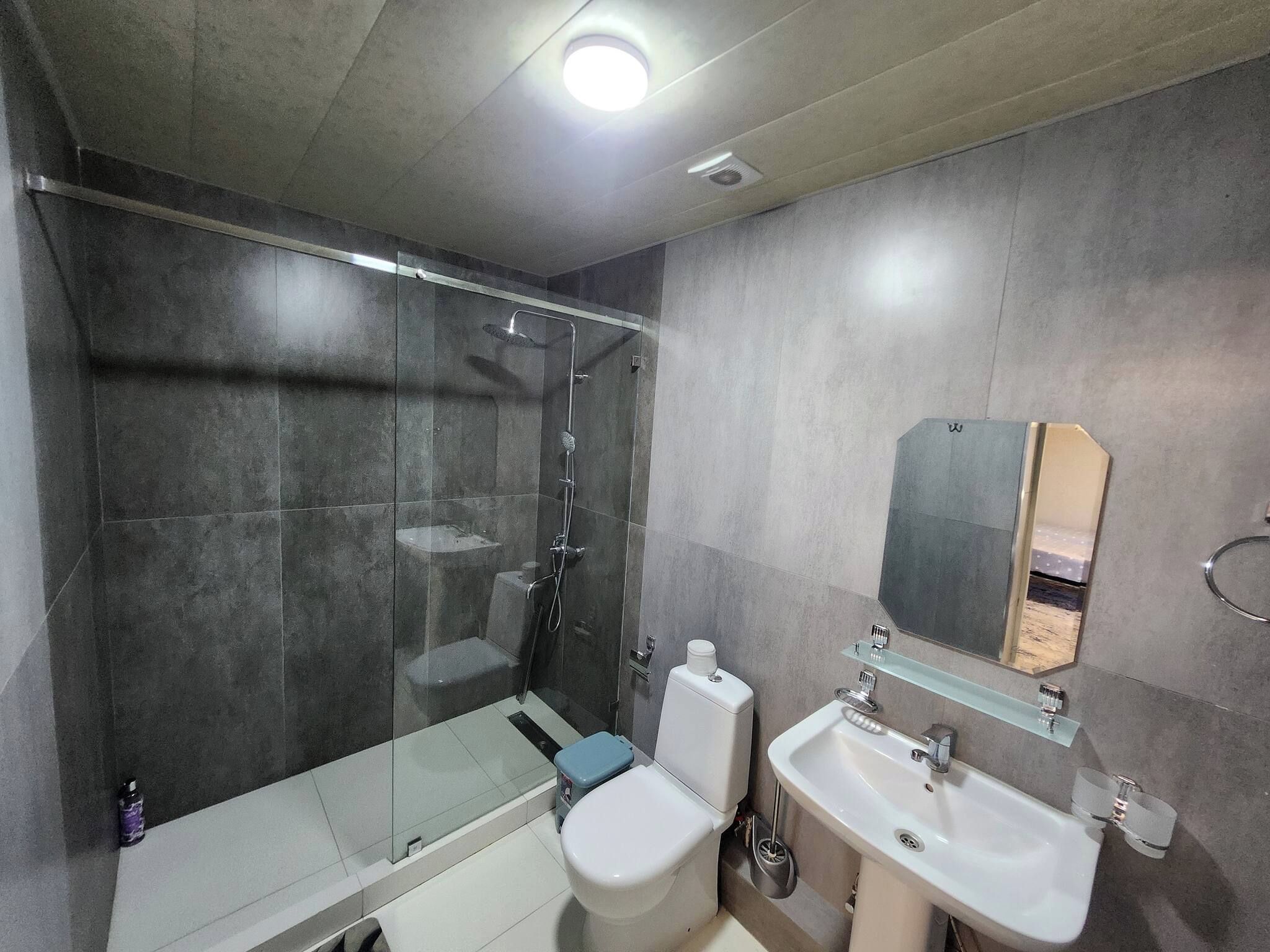 Ein modernes Badezimmer mit einer Duschkabine, einer Toilette und einem Waschbecken.