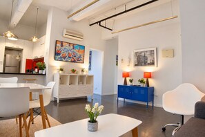 Ein modernes Wohnzimmer mit Essbereich, einem blauen Schrank und einem Bild an der Wand.