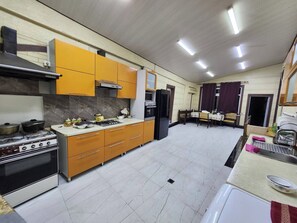A kitchen with a stove, oven, microwave, and cabinets. - Comfortable Triple Room – Perfect for Relaxation (Тошкент)