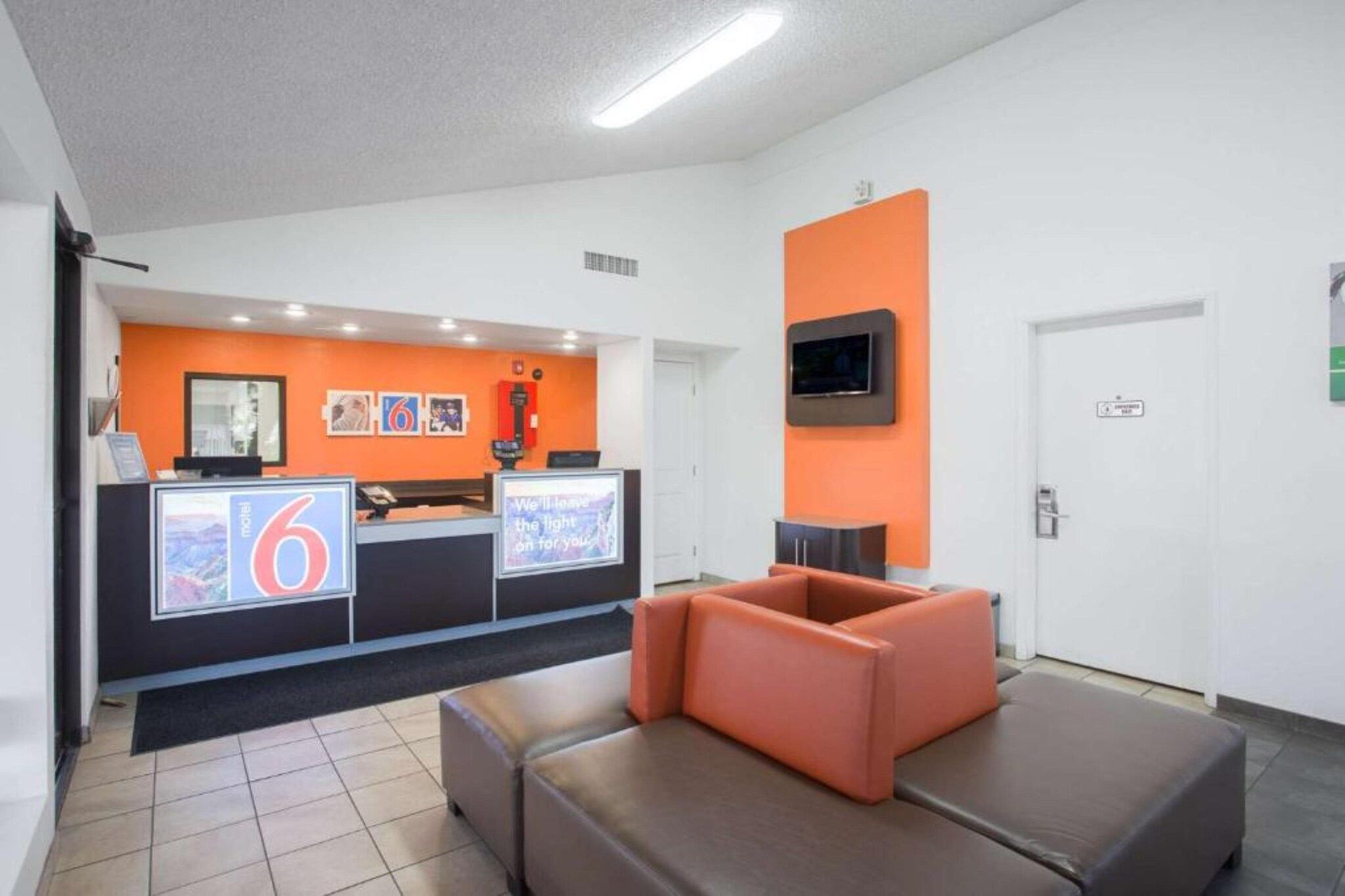 A reception area with a counter, seating, and a television.