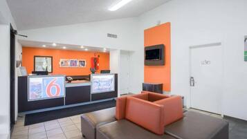 A reception area with a counter, seating, and a television.