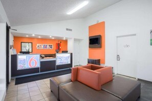 A reception area with a counter, seating, and a television.
