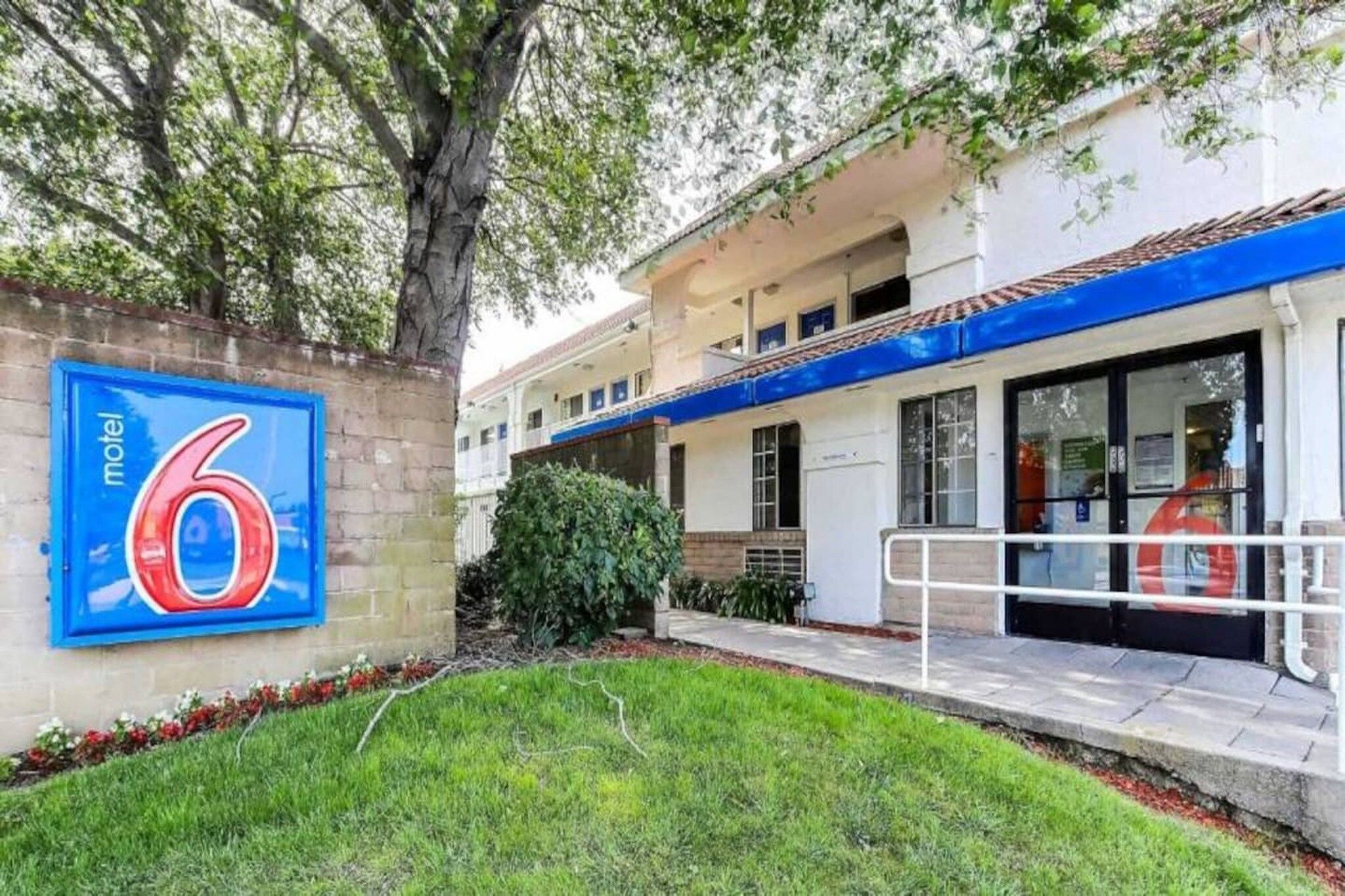 A motel with a large blue sign displaying the number 6.