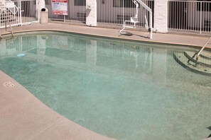 A swimming pool with a metal fence and a sign indicating no diving.