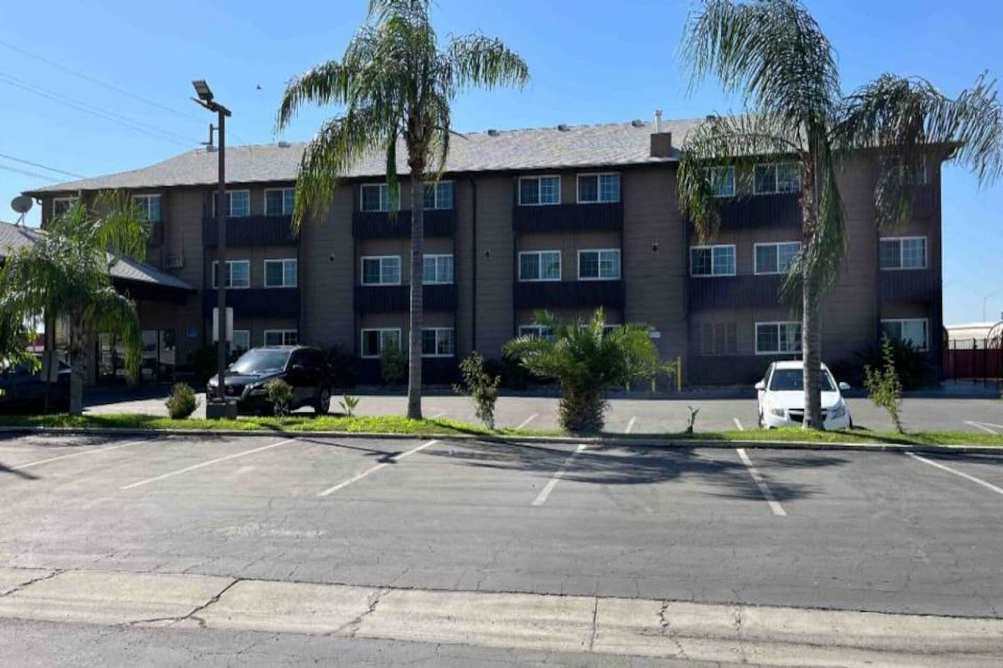 A multi-story building with a parking lot in front.