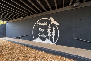 Pared con un diseño circular que muestra un pájaro, árboles y la frase 'Peaceful Easy Feeling'.