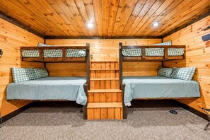 A cabin with two bunk beds, a wooden staircase, and a carpeted floor. - Broken Bow Lodge: Hot Tub, Sleeps 18 (Broken Bow)