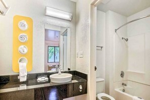A bathroom with a sink, mirror, towel rack, and shower. - 1 Queen Bed | Mini Fridge (Pinole)