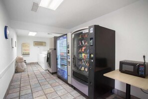 A corridor with vending machines, a microwave, and a refrigerator. - 2 Full Beds | Smoking (Kingman)