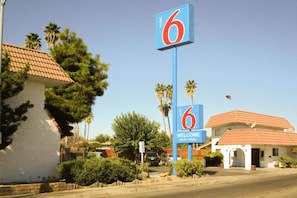 Een motelbord met het nummer 6 en een welkomstboodschap, dat de naam en faciliteiten van het etablissement aangeeft.