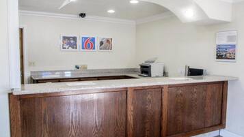 A kitchen with a wooden cabinet, a countertop, and a ceiling with recessed lighting.