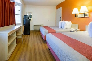 Une chambre d’hôtel avec deux lits, un bureau, une chaise, un radiateur et une fenêtre avec des rideaux.