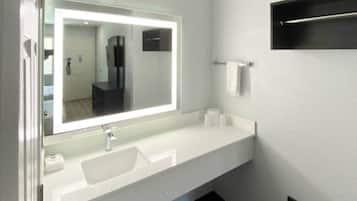 A bathroom with a white sink, a mirror, and a towel rack.