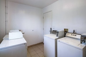 Une buanderie équipée de deux machines à laver et d’un sèche-linge.