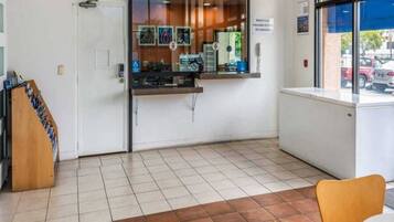 A reception area with a counter, a wheelchair-accessible sign, and a view of parked cars outside.