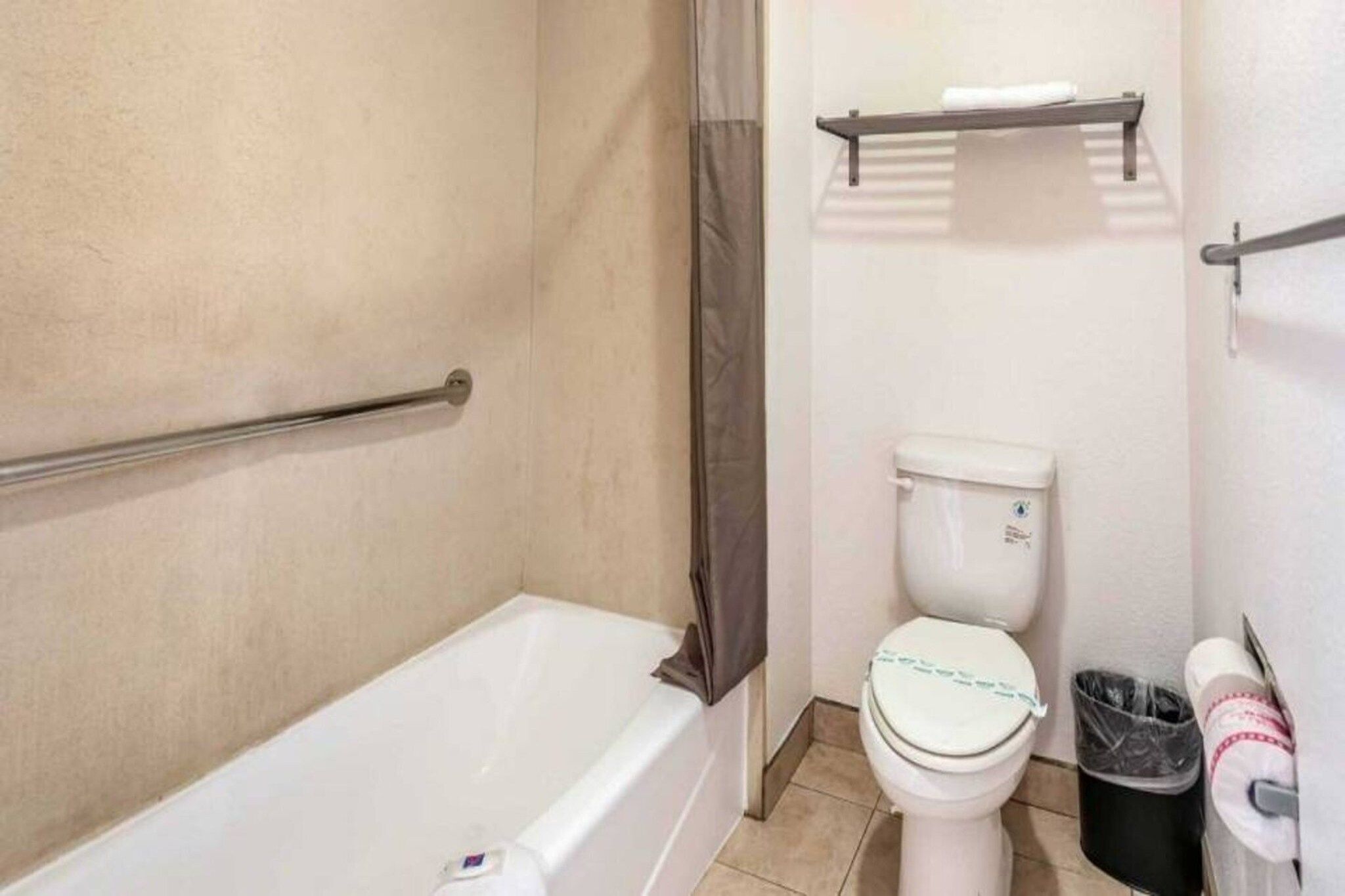 Un baño con bañera, inodoro y cortina de ducha.
