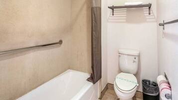 Un baño con bañera, inodoro y cortina de ducha.