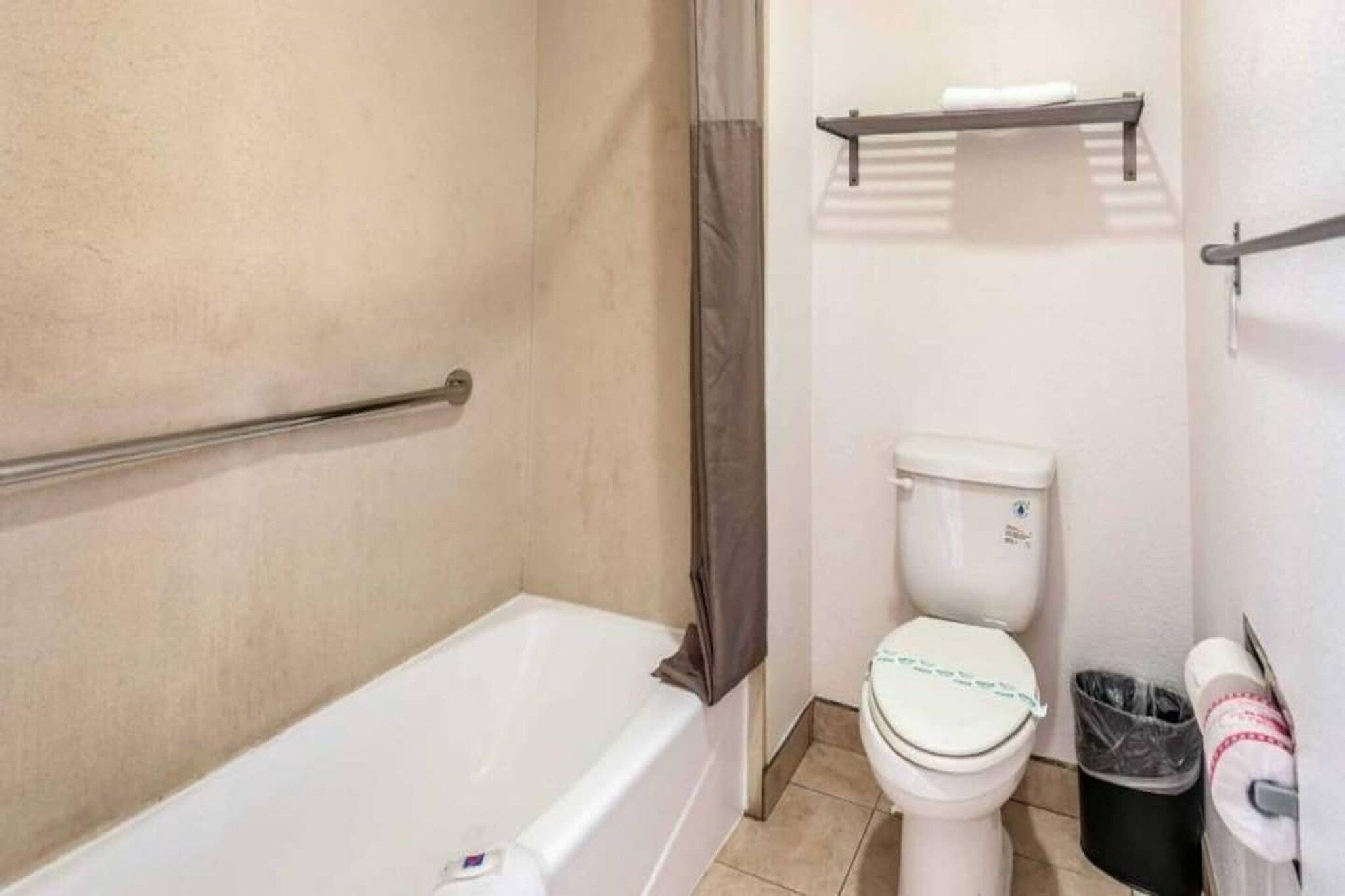 A bathroom with a bathtub, toilet, and a shower curtain.