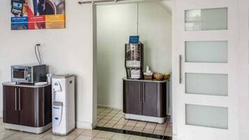 A kitchenette with a microwave, coffee maker, and a refrigerator.