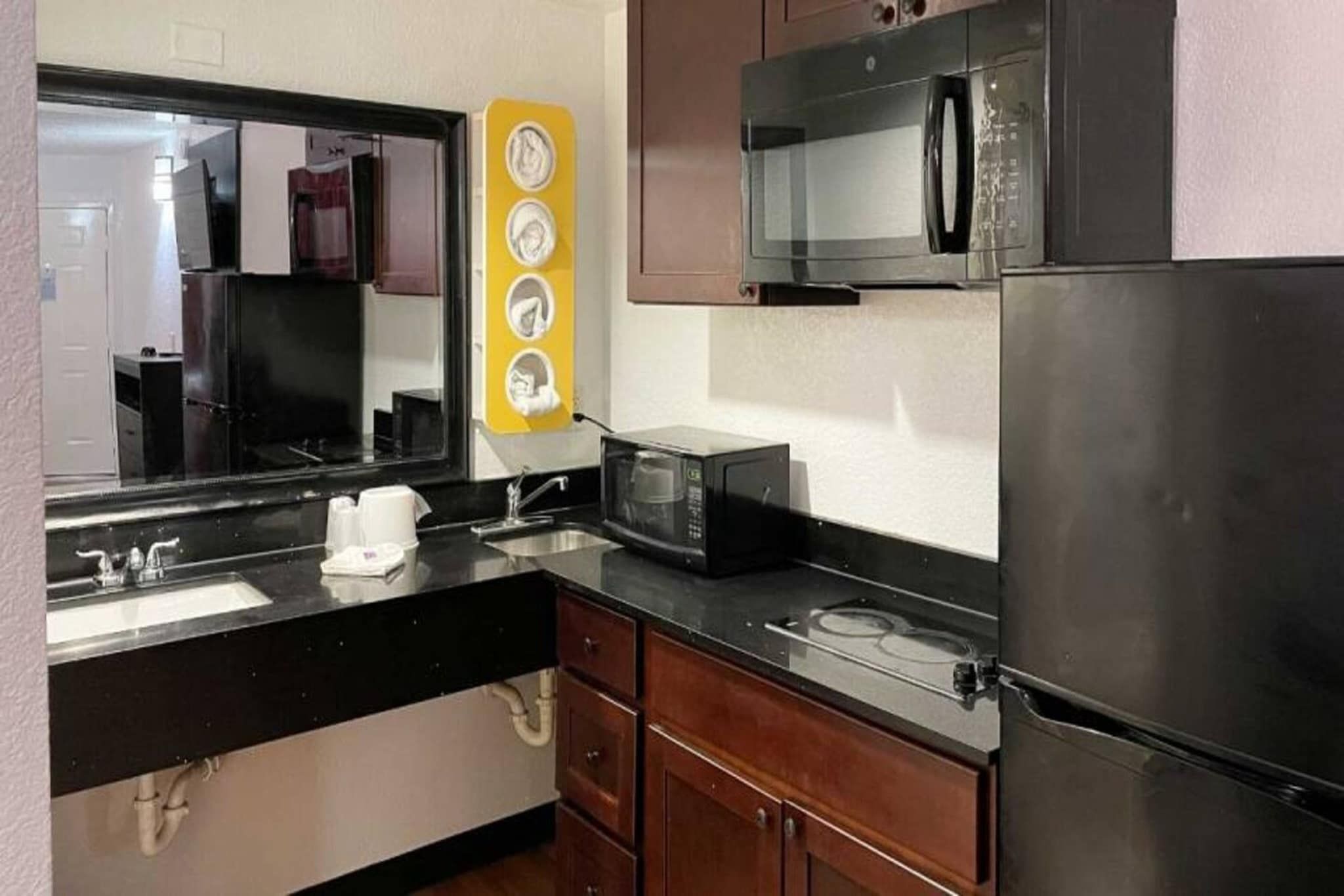 A compact kitchen with a sink, a microwave, a stove, and a refrigerator.