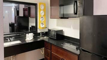 A compact kitchen with a sink, a microwave, a stove, and a refrigerator.
