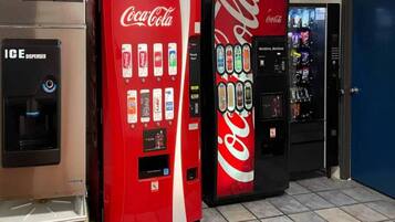 Three Coca-Cola vending machines in a commercial setting.