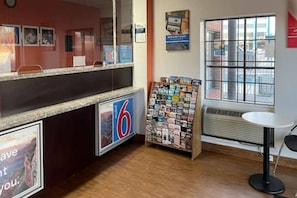 Ein Hotel-Empfangsbereich mit Theke, Zeitschriftenständer und Fenster mit Blick.