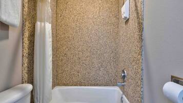 A bathroom with a bathtub, a toilet, and a shower curtain.